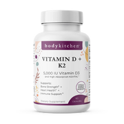 A bottle of Body Kitchen Vitamin D + K2 supplement with 60 capsules, featuring 5000 IU of Vitamin D3 and 180 mcg of K2. The label highlights bone strength, heart health, and immune support.