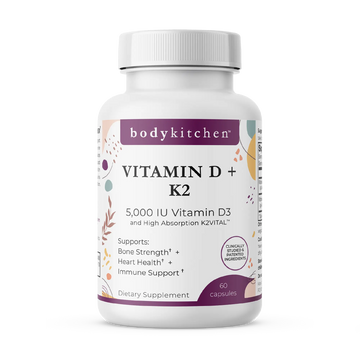 A bottle of Body Kitchen Vitamin D + K2 supplement with 60 capsules, featuring 5000 IU of Vitamin D3 and 180 mcg of K2. The label highlights bone strength, heart health, and immune support.