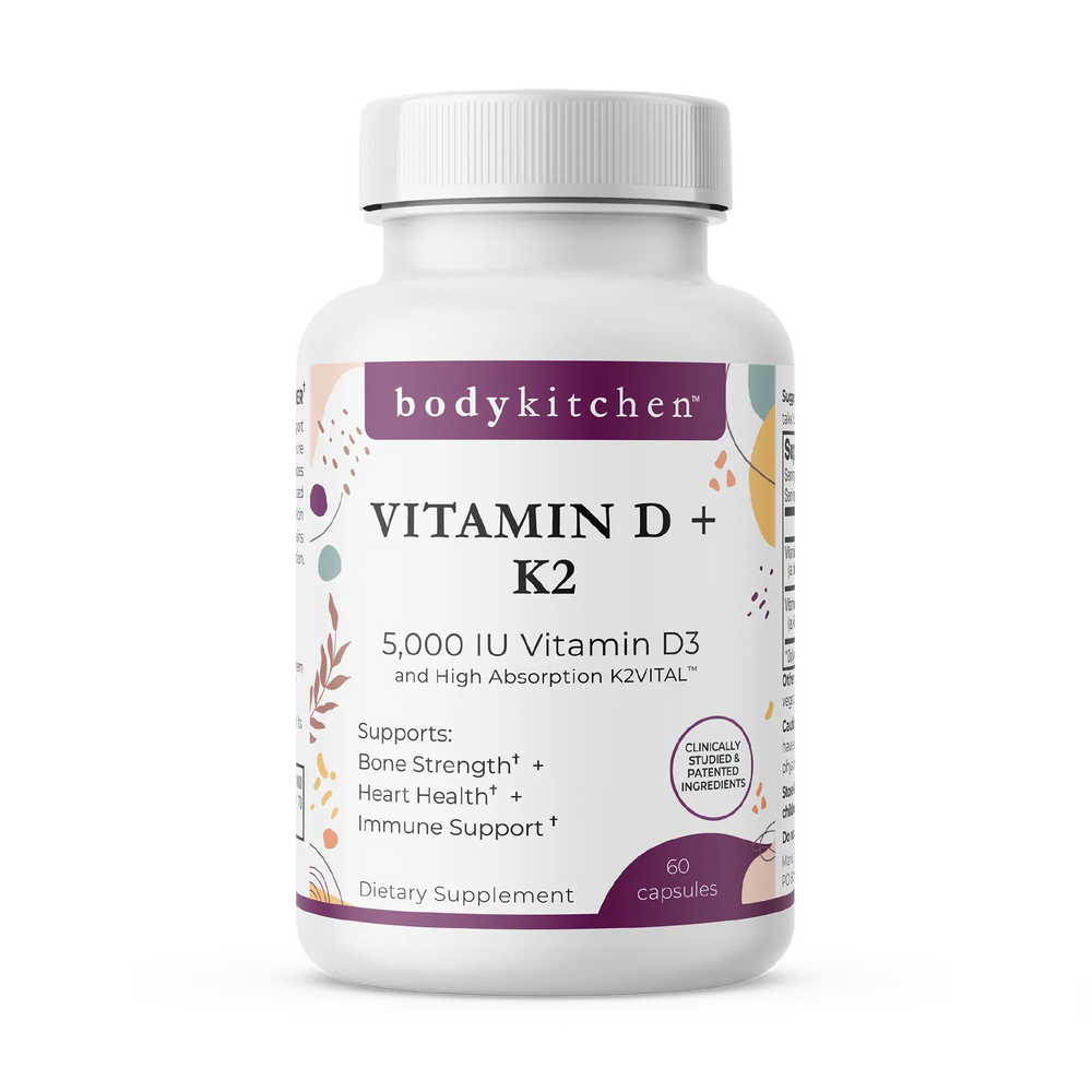 A bottle of Body Kitchen Vitamin D + K2 supplement with 60 capsules, featuring 5000 IU of Vitamin D3 and 180 mcg of K2. The label highlights bone strength, heart health, and immune support.